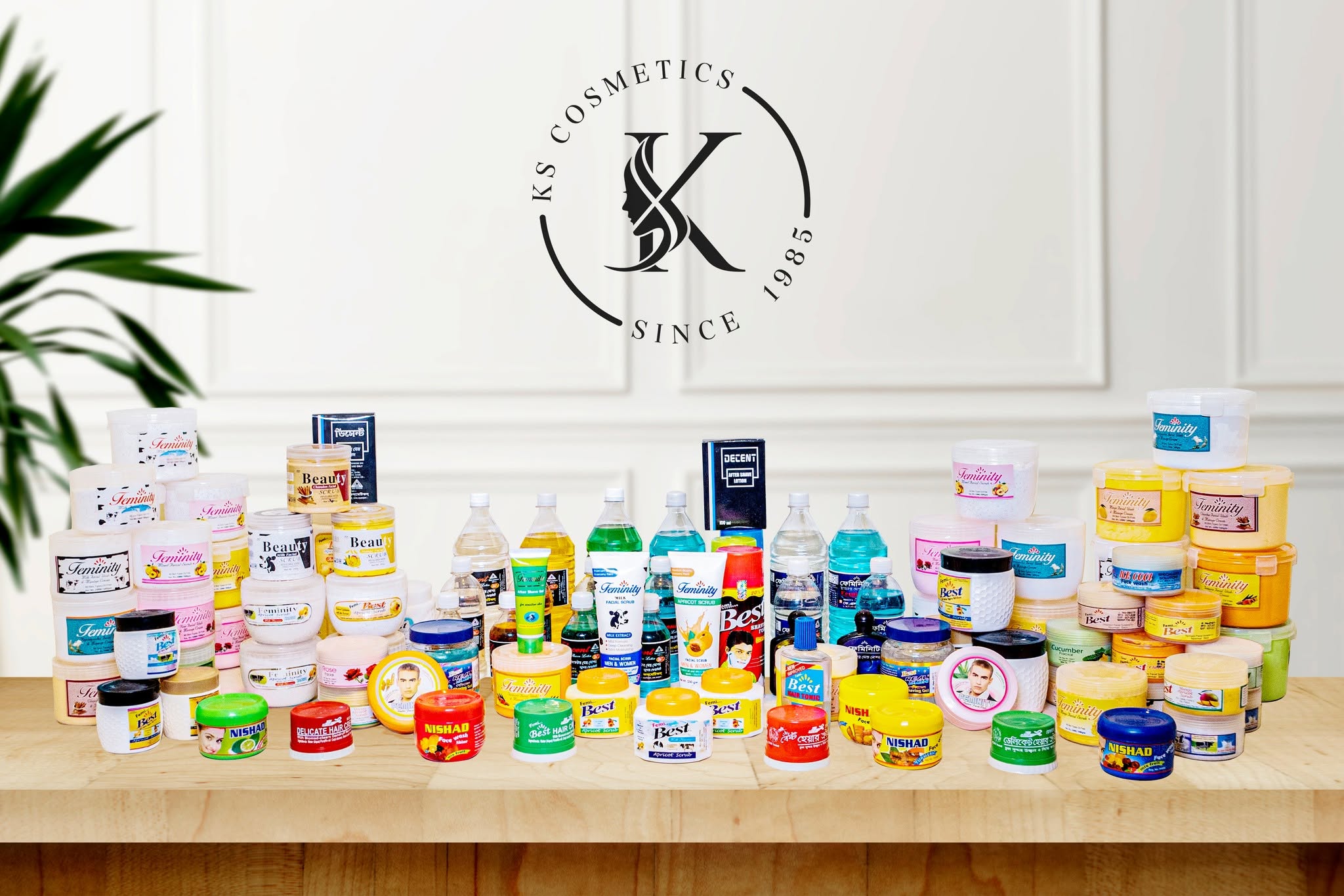 The full KS Cosmetics product range — Feminity, Best, Nishad, Beauty and Decent jars, tubes and bottles on a wooden table